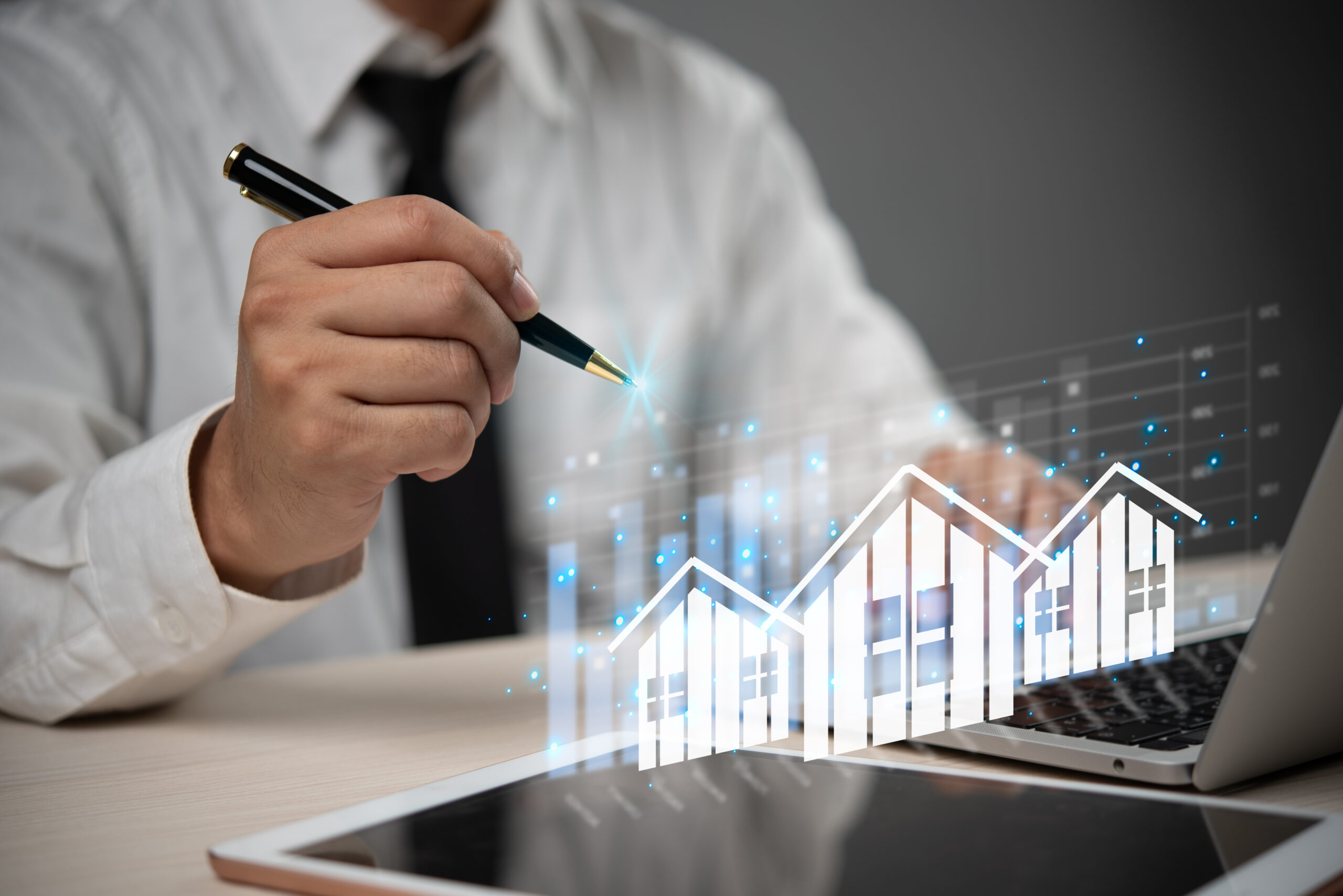 The laptop screen shows a house and a graph.Real estate concept business, home insurance and real estate protection. Buy and sell houses and real estate online on a virtual screen